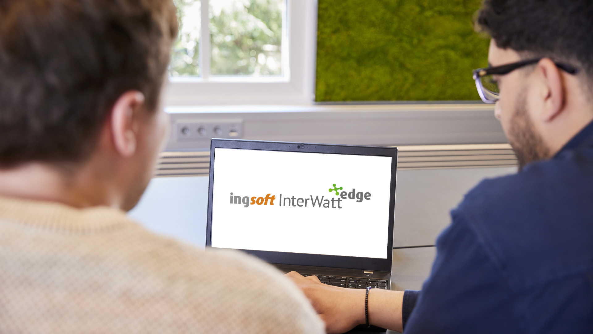 Personen blicken auf Bildschirm der das Logo von IngSoft InterWatt Edge zeigt